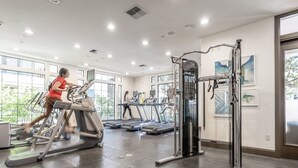Una palestra con tapis roulant, macchinari per pesi e attrezzature per esercizi.