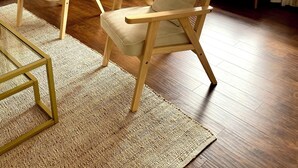 A cozy living room with two wooden armchairs, a bench, a woven floor rug, a standing lamp, and a large window with curtains. - Peaceful 2 Bedroom Forest Retreat w/ Sauna! (Ithaca)