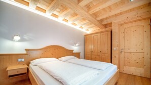A wooden bedroom with a bed, nightstands, and built-in wardrobes.