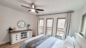 Un dormitorio con cama, cómoda, espejo y ventilador de techo.