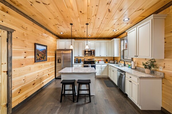 Enjoy cooking and dining in this kitchen with a central island, barstools, and stainless steel appliances.