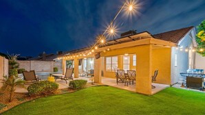 A house with a patio, outdoor seating, and a barbecue area.