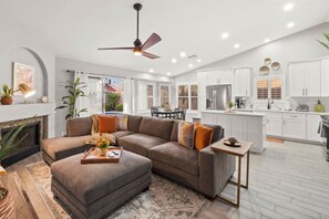 A modern living room with a sectional sofa, a fireplace, and a dining area.