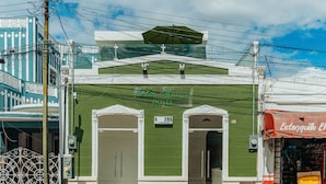 Un edificio verde con un letrero que dice "Italia Station Hotel" y un precio de 295 dólares.