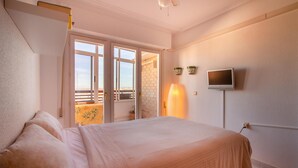 A bedroom with a bed, a TV, a balcony with a table and chairs, and a door leading outside. - Nice apartment in Torrevieja with WiFi (Torrevieja)