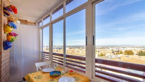 A balcony with a table set for two, overlooking a cityscape. - Nice apartment in Torrevieja with WiFi (Torrevieja)