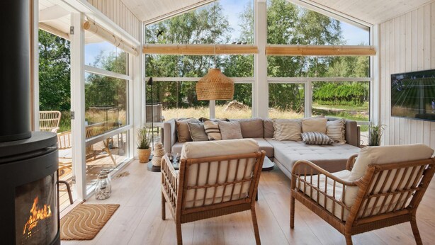 A cozy living room with a large window, a fireplace, and a comfortable seating area. - 3 bedroom awesome home in Gørlev (Gørlev)