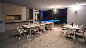 A modern dining area with a pool table, a fireplace, and a view of the pool. - Stunning home in Donji Prolozac with sauna (Donji Prolozac)