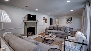 A living room with a fireplace, sofas, and a coffee table. - Serene Home in Fondren Location Near Hospitals (Jackson)