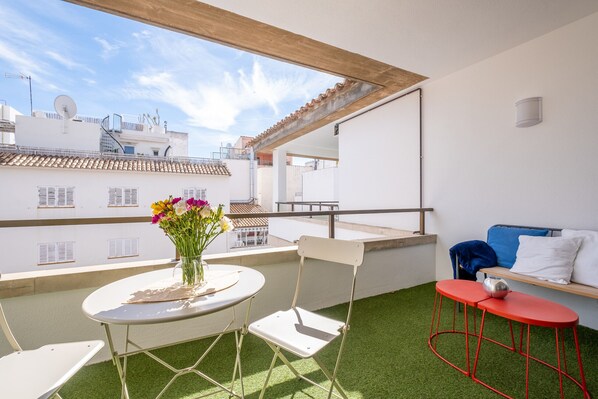 A balcony with a table, chairs, and a sofa. - Holiday home Balaixa 8 by the sea (Puerto Pollensa)