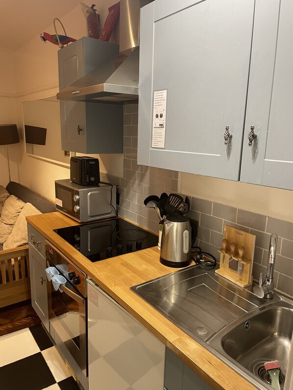 A compact kitchen with a microwave, toaster, kettle, and a sink. - Central London, Zone 1 Westminster (London)