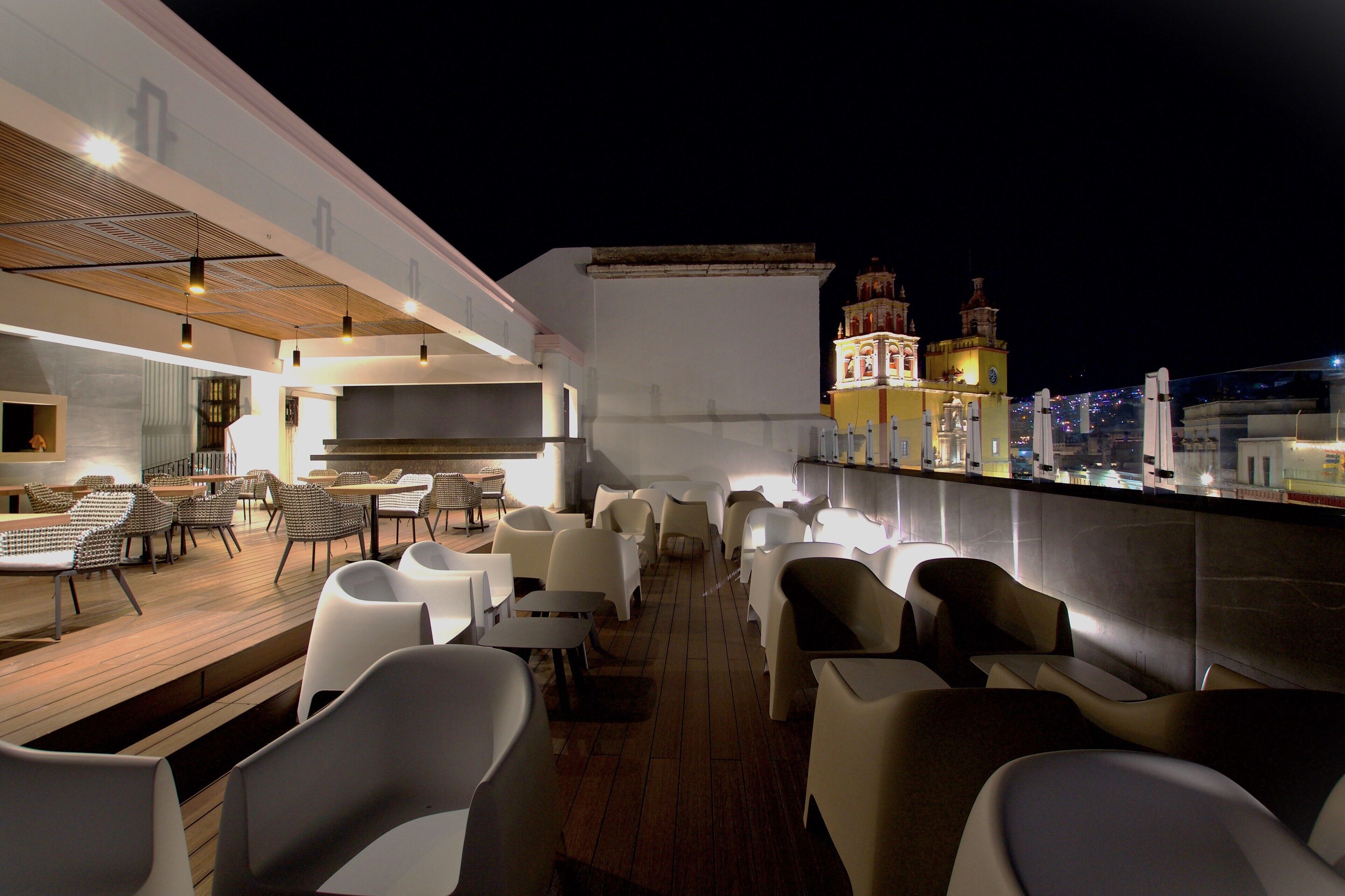 An outdoor dining area with modern furniture and a view of a historic building in the background.