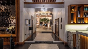 Eine moderne Hotelhalle mit einer zentralen Treppe, einer Rezeption und einer Bar.