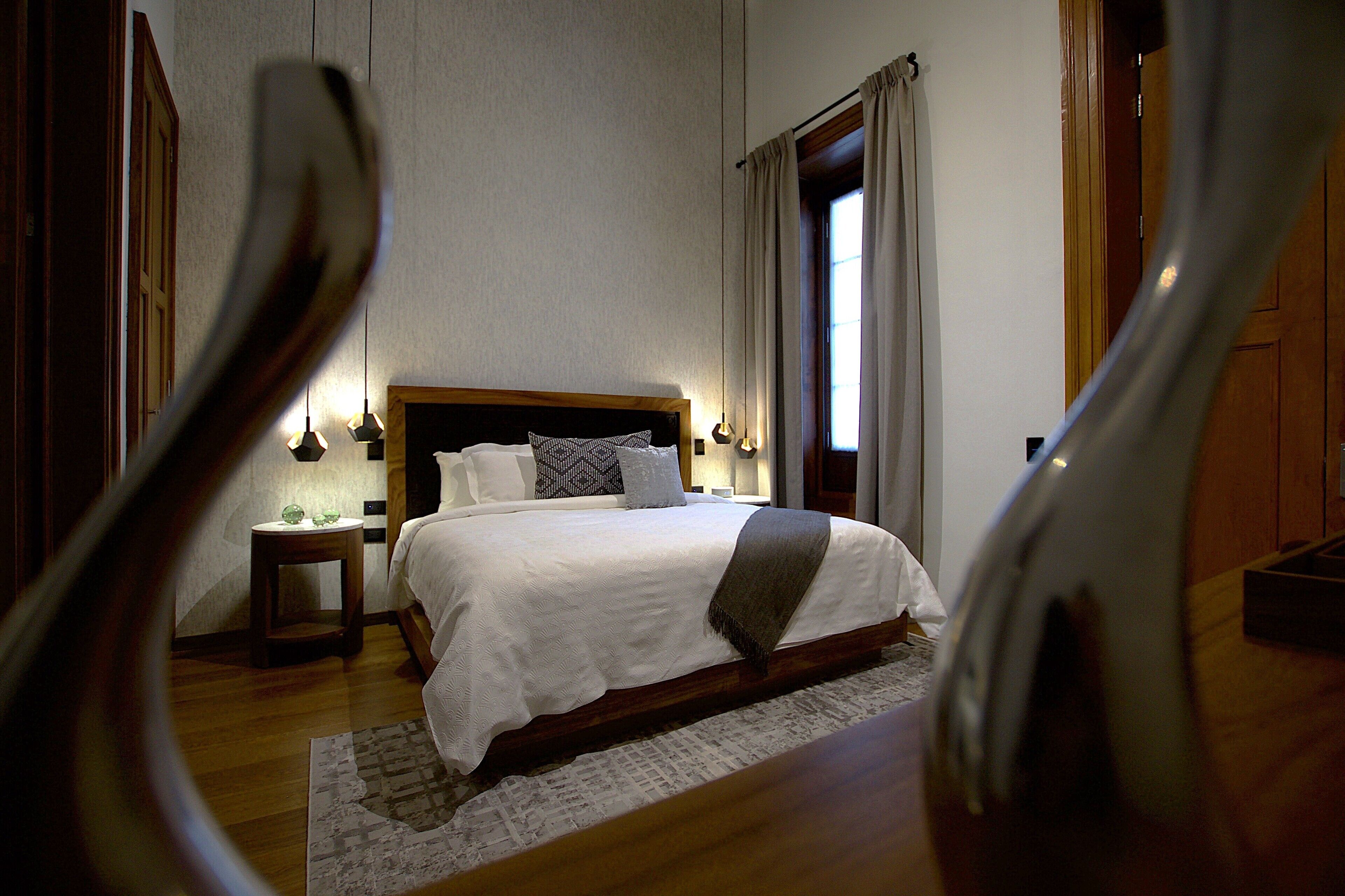 A bedroom with a large bed, a bedside table, and a nightstand.