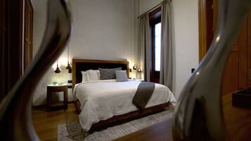 A bedroom with a large bed, a bedside table, and a nightstand.