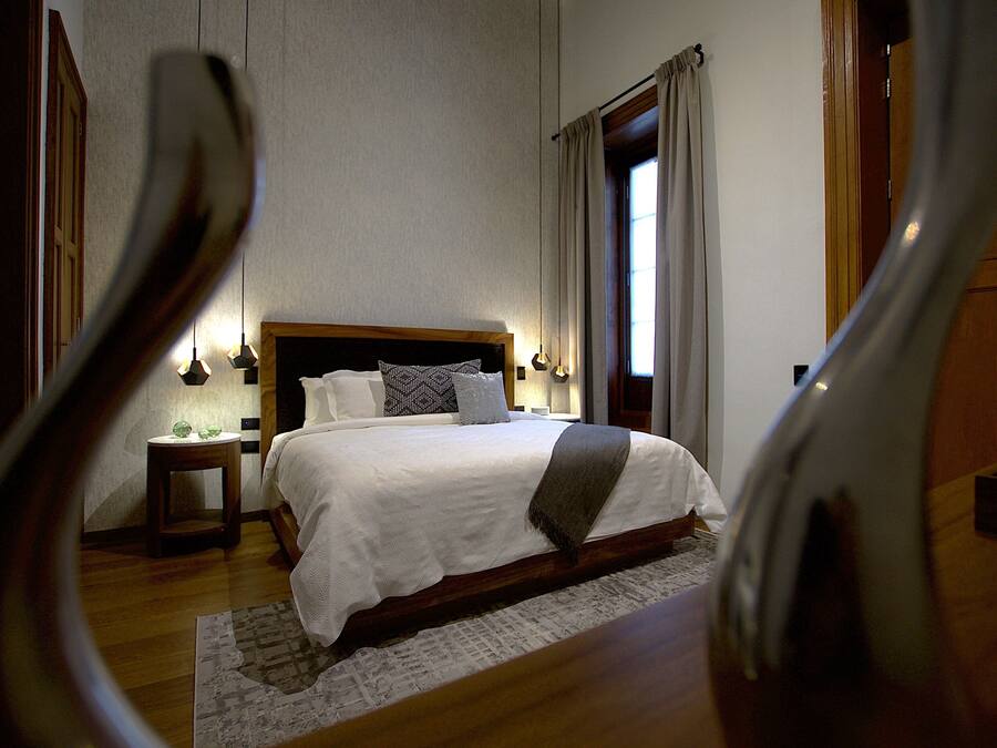 A bedroom with a large bed, a bedside table, and a nightstand.