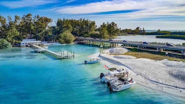 A coastal area with boats, a pier, and a bridge connecting to a mainland. - House has power ,Fast WIFI，Near Anna Maria beach (Bradenton)