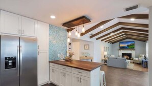 A modern kitchen with white cabinets, a stainless steel refrigerator, a wooden island, and a tiled backsplash. - House has power ,Fast WIFI，Near Anna Maria beach (Bradenton)