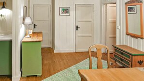 A room with a wooden desk, a chair, a dresser, a lamp, and two doors with framed pictures. - Awesome home in Fyresdal with kitchen (Fyresdal)