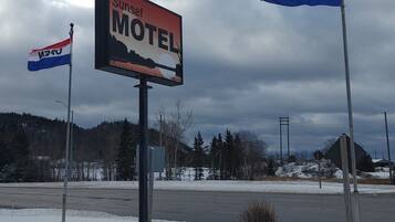 Motel Schild mit Sonnenuntergangsdarstellung, umgeben von Schnee.
