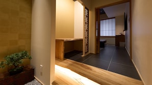 A hallway with a wooden bench, a small potted plant, and a traditional Japanese sliding door. - MURE Beppu (Beppu)