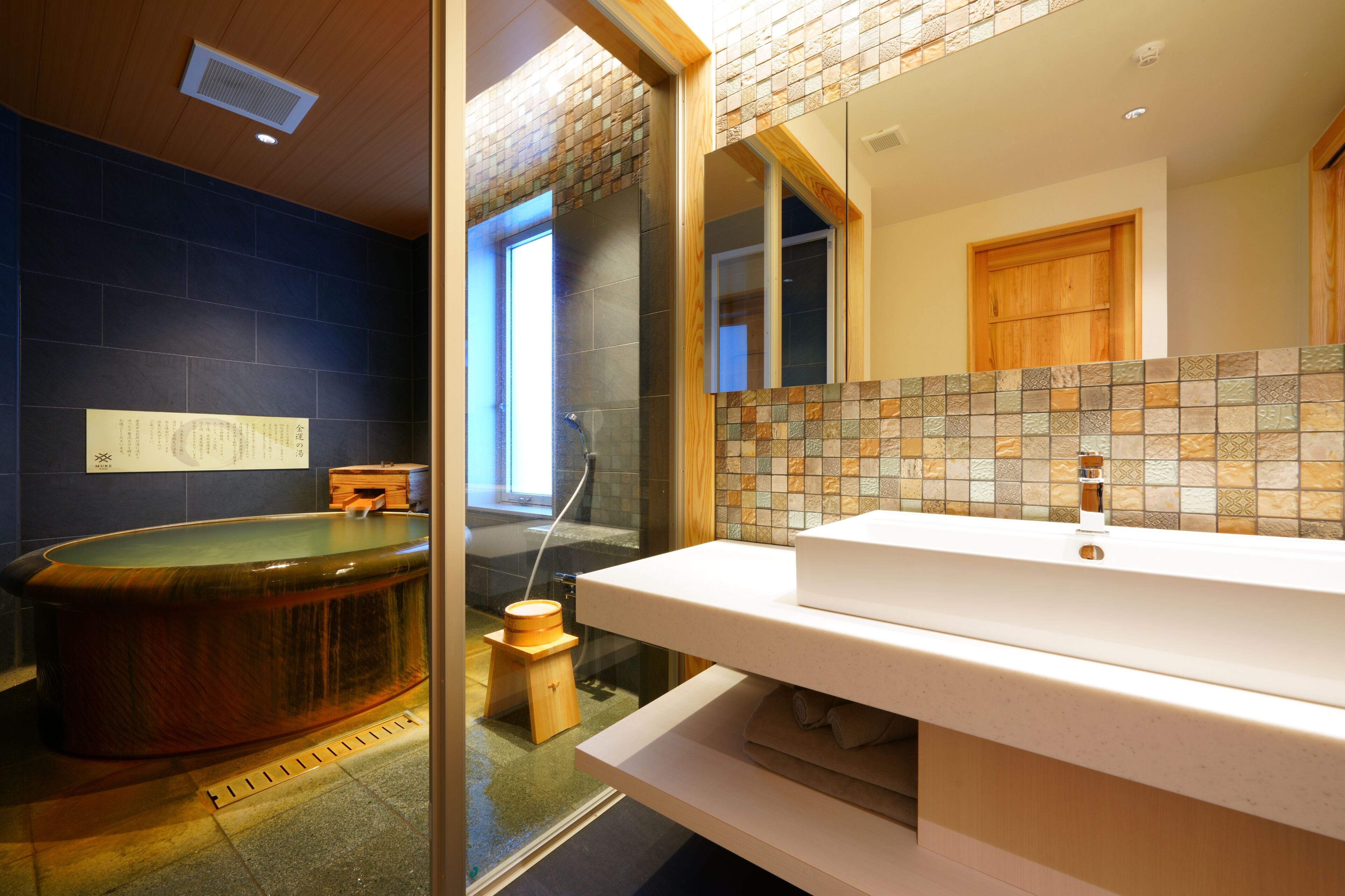 A bathroom with a bathtub, a sink, and a mirror.
