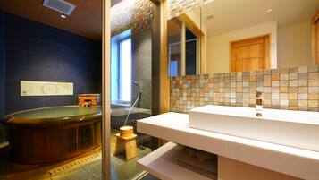 A bathroom with a bathtub, a sink, and a mirror.