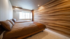 Quarto com uma cama grande, um painel de parede de madeira e uma janela com persianas.