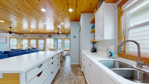 Una cocina amplia con una isla grande, techo de madera y vistas al exterior.
