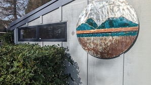 Fachada de edificio con un panel decorativo circular que muestra un paisaje de montaña.