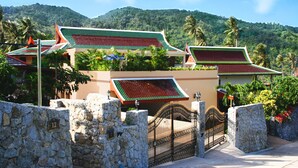 A traditional Thai building with a stone gate and a mountain backdrop. - Luxury Villa with private chef, full staff, infinity pool , Ocean Views (Tambon Karon)