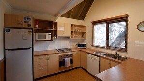 A compact kitchen with a refrigerator, microwave, stove, oven, and dishwasher.