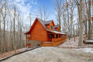 A log cabin with a porch and a stone foundation, surrounded by a forest. - Welcome to Heaven in the beautiful Hocking Hills! (Logan)