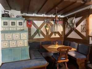 Ein rustikaler Essbereich mit Holzbänken und einem Tisch, dekoriert mit Vintage-Gegenständen und einer hängenden Leuchte.