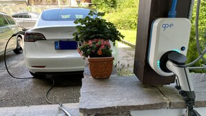 A Tesla charging station with a potted plant beside it. - Spacious apartment 3 with balcony (Berchtesgaden)