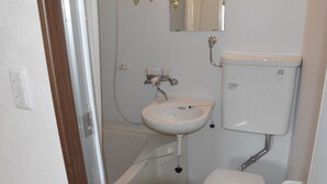 Een badkamer met een witte wastafel, toilet en bad.