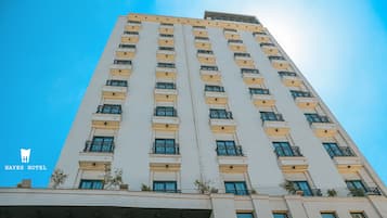 Um edifício alto de hotel, com várias varandas e janelas.