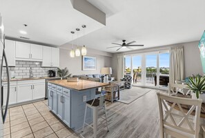 Gather in this open-concept Laketown Wharf condo featuring a full kitchen, island seating, comfortable living space, and bright lake views.