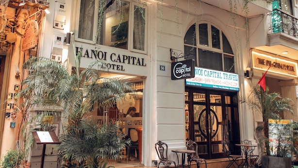 Hotel Hanoi Capital con zona de estar exterior y vegetación.