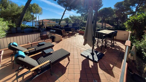 An outdoor patio with sun loungers, a table, and a pergola. - Cap D'Antibes sea, swimming pool, 2 large terraces, nature and pines (Antibes)