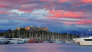 A marina with several yachts docked and a historic building in the background. - Cap D'Antibes sea, swimming pool, 2 large terraces, nature and pines (Antibes)