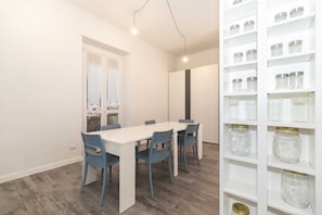 Une cuisine moderne avec des armoires blanches, un plan de travail blanc et un four encastré.