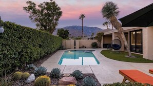 A backyard with a swimming pool, surrounded by cacti and succulents, and a view of mountains. - Stylish Palm Springs Retreat with Pool (Palm Springs)