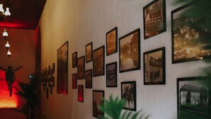 A wall with framed photographs and a row of tables and chairs. - Fibar Hotel Zincirlihan (Aydin)