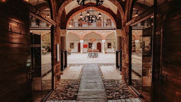 A grand entrance with a stone pathway leading to a courtyard, featuring a central fountain and seating area. - Fibar Hotel Zincirlihan (Aydin)