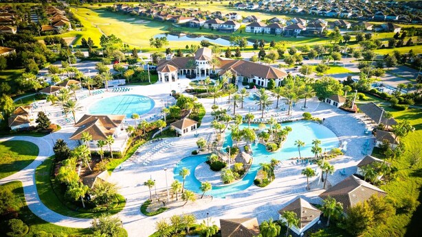 An aerial view of a resort with multiple swimming pools, a golf course, and residential buildings. - Free Baby Amenities! Stunning Disney Themed Villa! Game Room, Sunny Pool & Spa (Davenport)