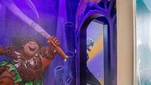 A vibrant mural with a character holding a staff, a large arched doorway, and a glimpse of a room with a bed and a window. - Free Baby Amenities! Stunning Disney Themed Villa! Game Room, Sunny Pool & Spa (Davenport)