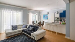 Ein modernes Wohnzimmer mit Sofa, Essbereich und Küche.
