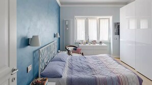 Ein Schlafzimmer mit Bett, Schreibtisch und Kleiderschrank.