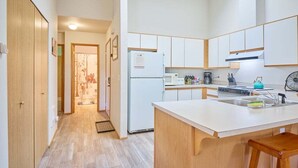 Una cocina moderna con armarios blancos, una isla central y un microondas.